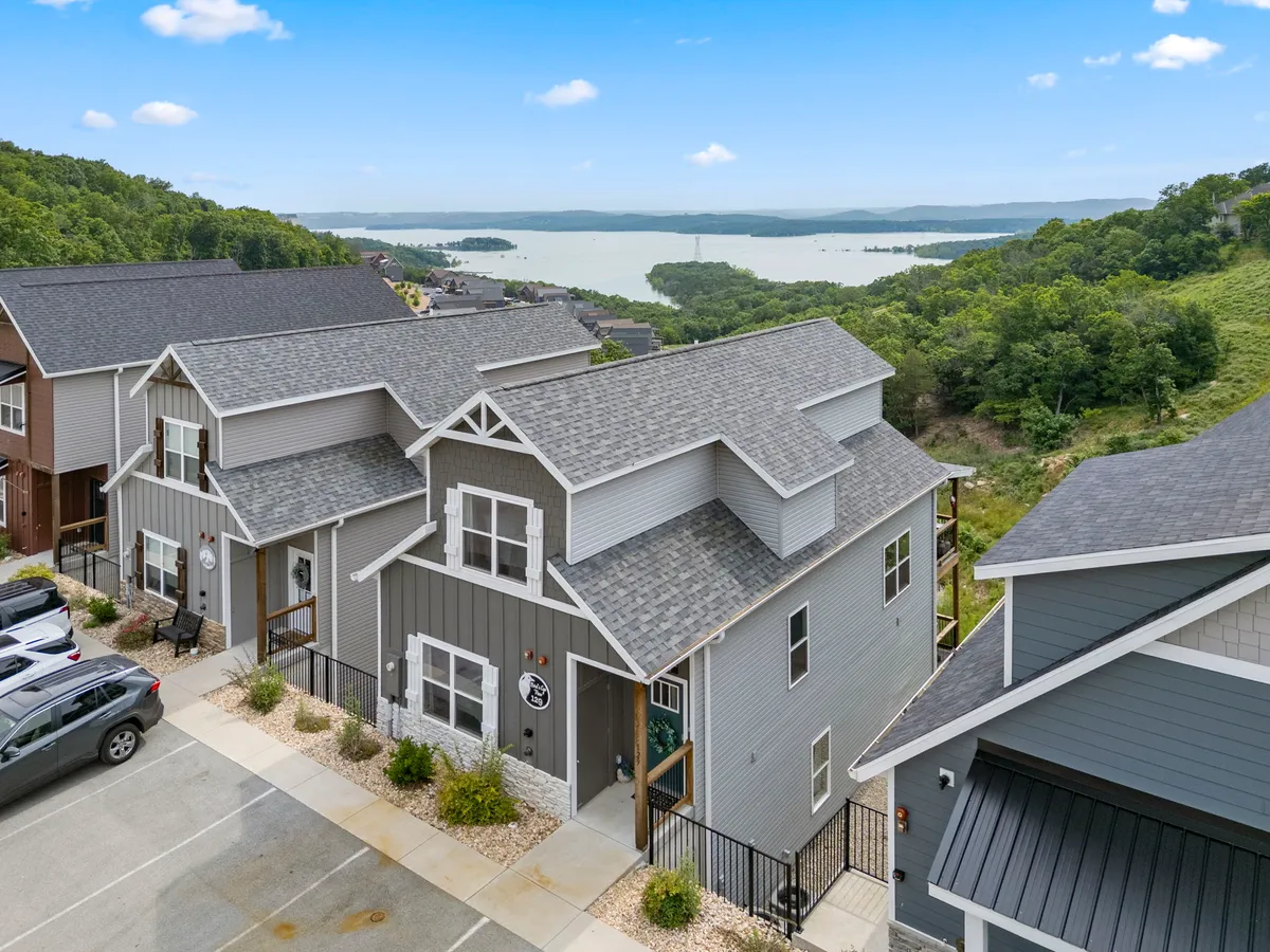 A serene exterior shot of modern homes with landscaped gardens overlooking a peaceful lake. The setting radiates tranquility, offering sunset views and a sense of retreat after an adventurous day out.